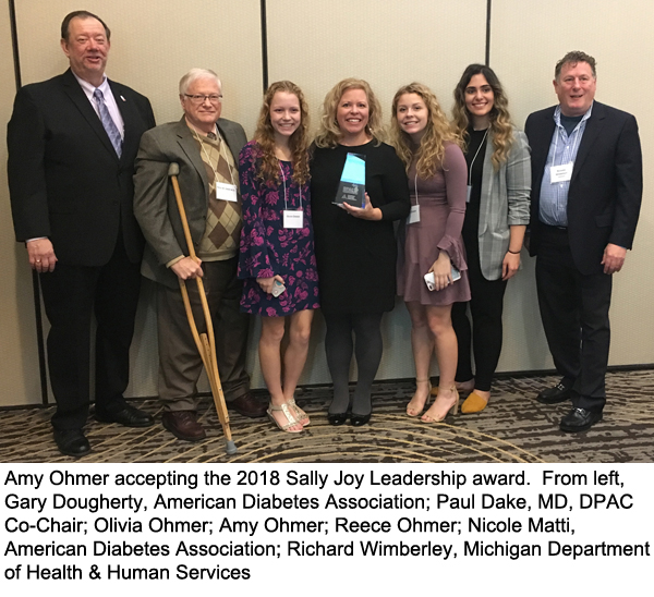 Amy Ohmer accepting the 2018 Sally Joy Leadership Award with (from left) Gary Dougherty, American Diabetes Association; Paul Dake, MD, DPAC Co-Chair; Olivia Ohmer; Amy Ohmer; Reece Ohmer; Nicole Matti, American Diabetes Association; Richard Wimberley, Michigan Department of Health & Human Services